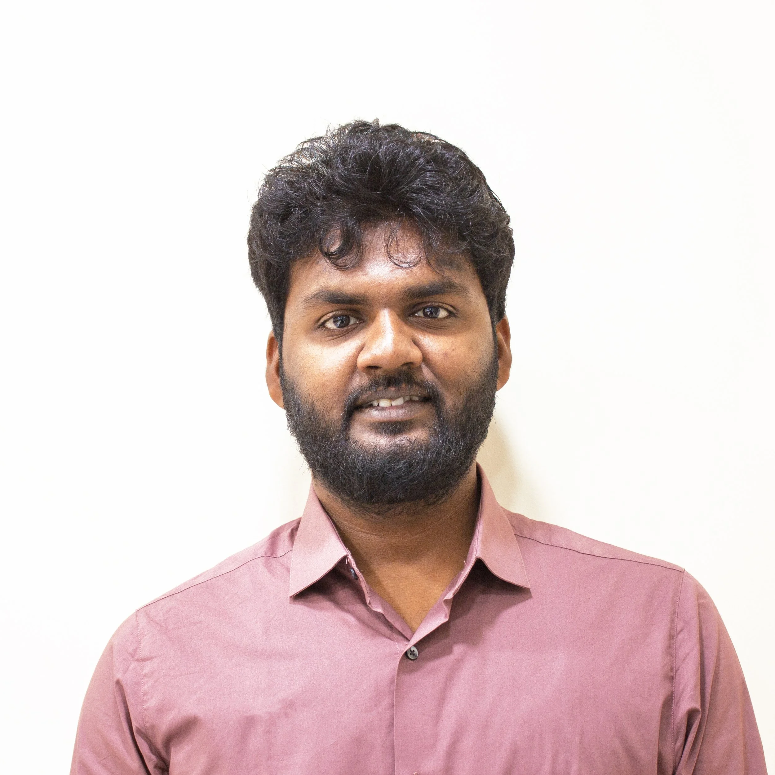 Woman sitting on a bench in a room with neutral decor, sunlight casting shadows on the wall.