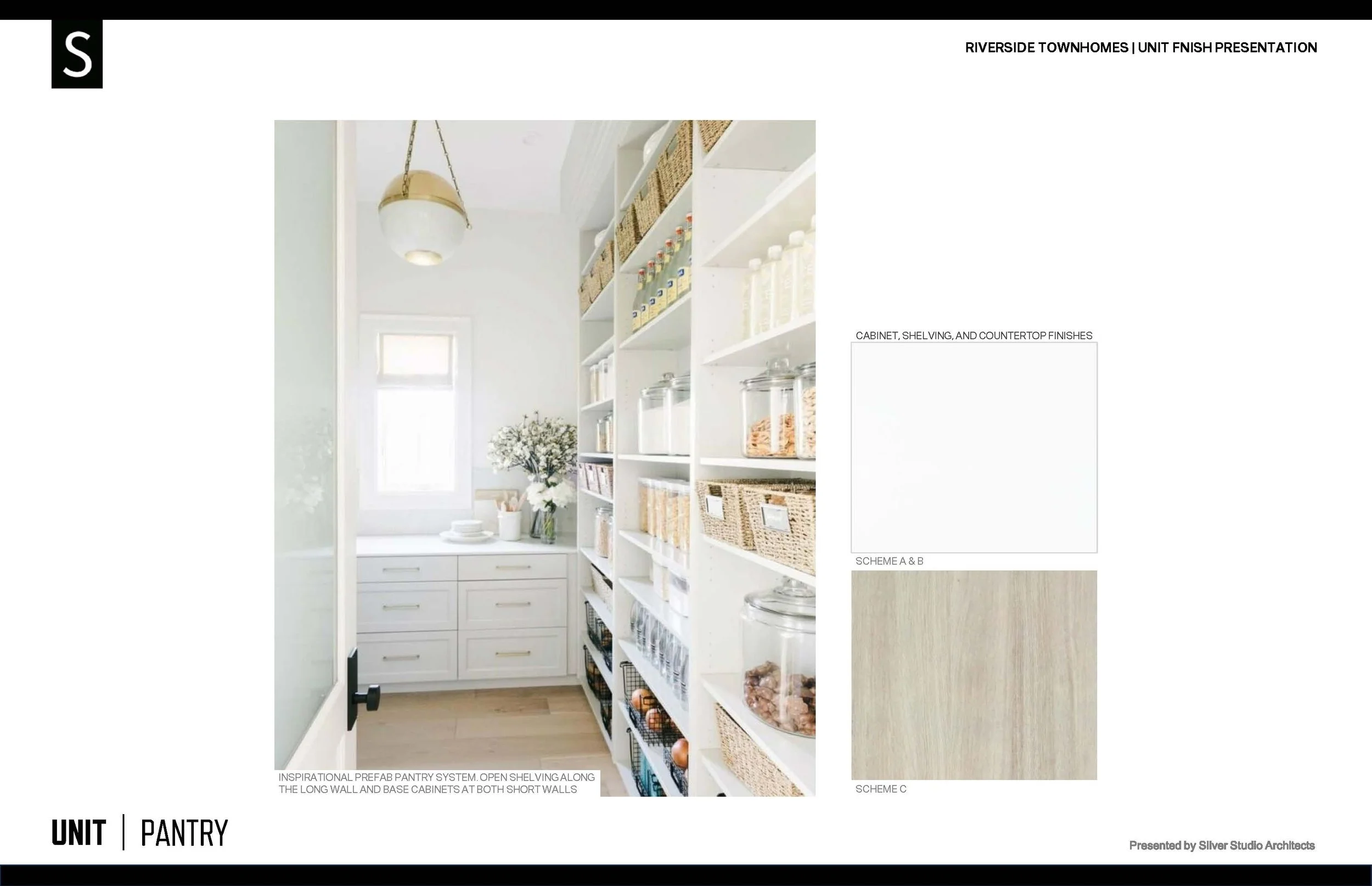 Interior view of a pantry with white cabinetry, open shelving, and containers for food storage, with a small window and a ceiling light fixture.
