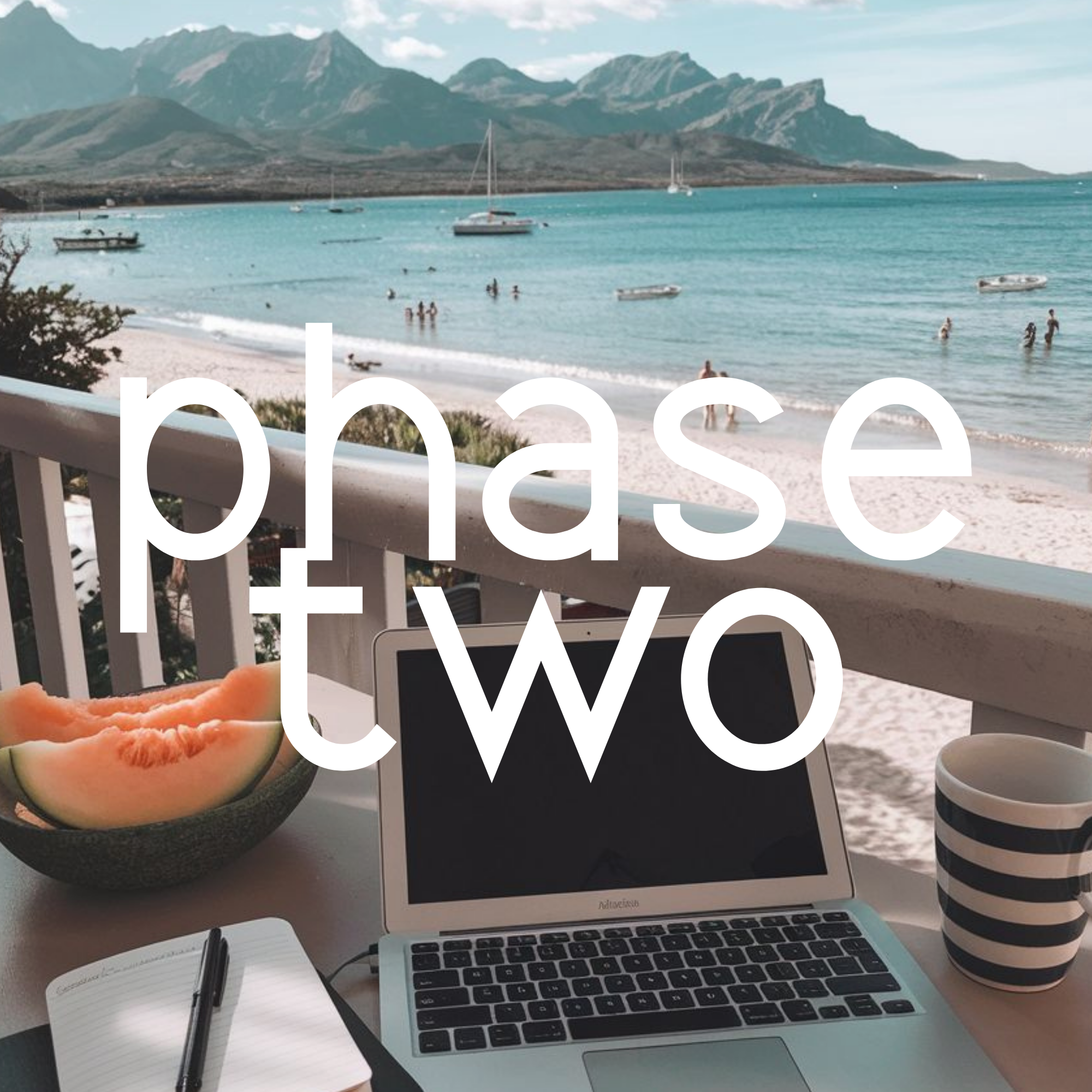 Open laptop on a desk, open notebook with a pen, a watermelon slice, and a view of a beach with boats and people swimming, with mountains in the background.