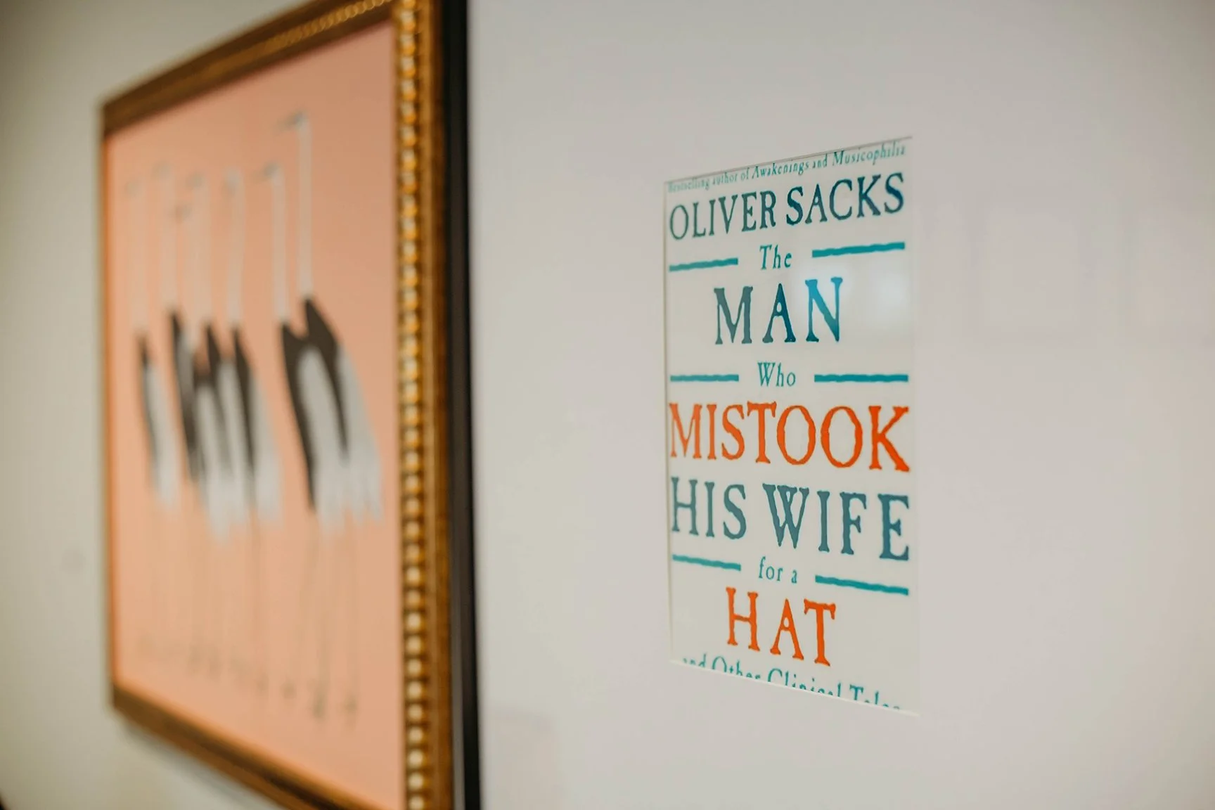 Framed poster with text mentioning Oliver Sacks, awakening, musicophilia, and a story about a man who mistook his wife for a hat.