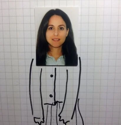 A photo of a woman’s face on paper with a hand-drawn cartoon body on graph paper.