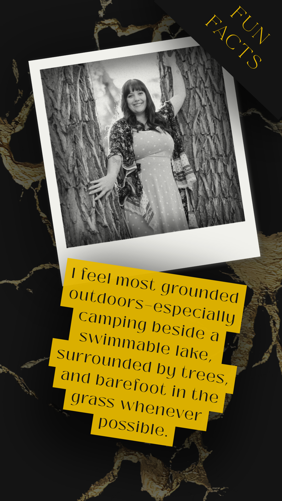Black and white photo of a woman smiling and leaning against a tree outdoors, surrounded by trees and grass.