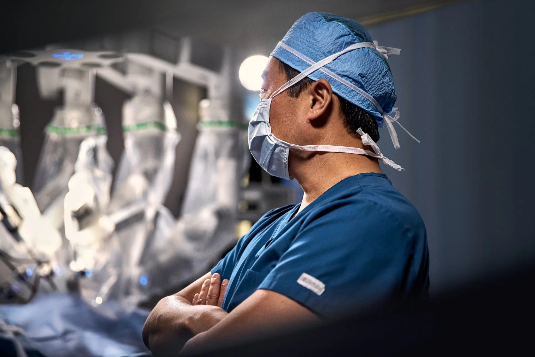 surgeon with arms crossed in front of operating table