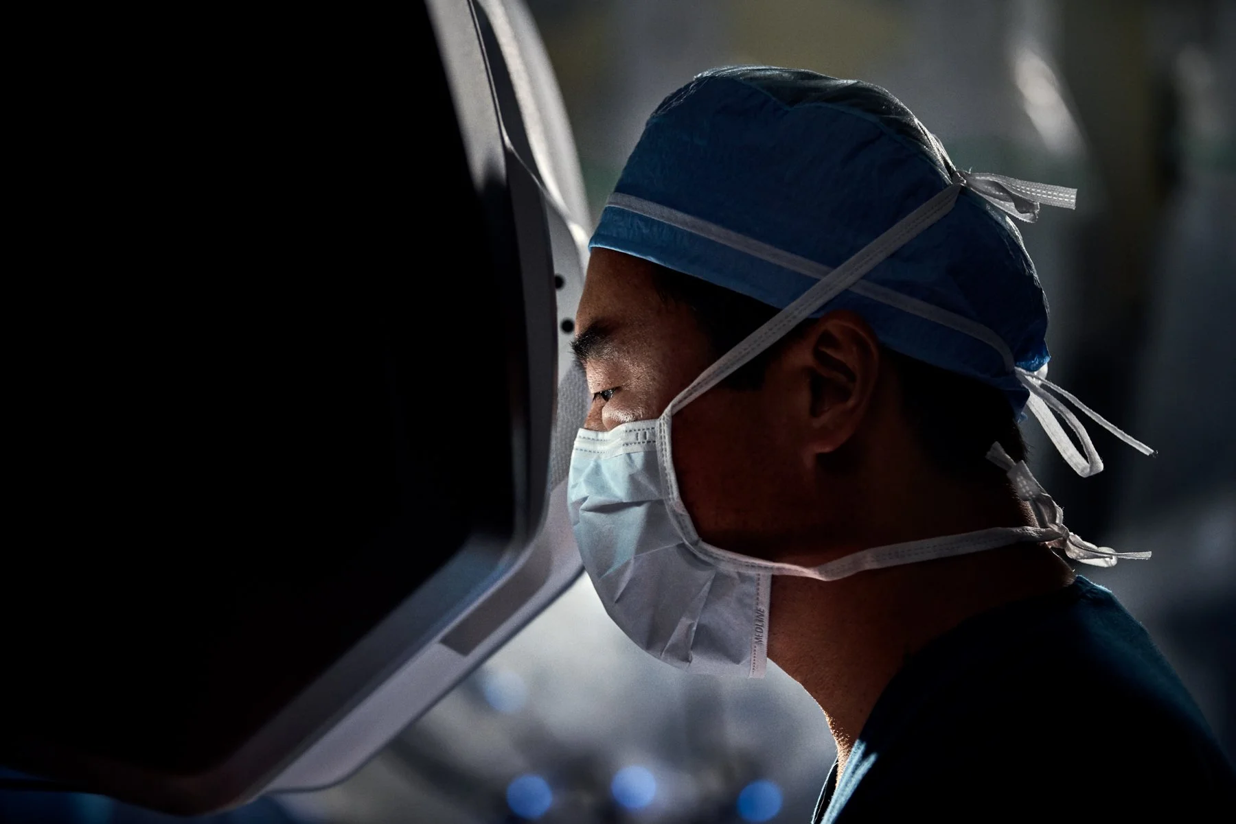 surgeon looking into surgical robot monitor