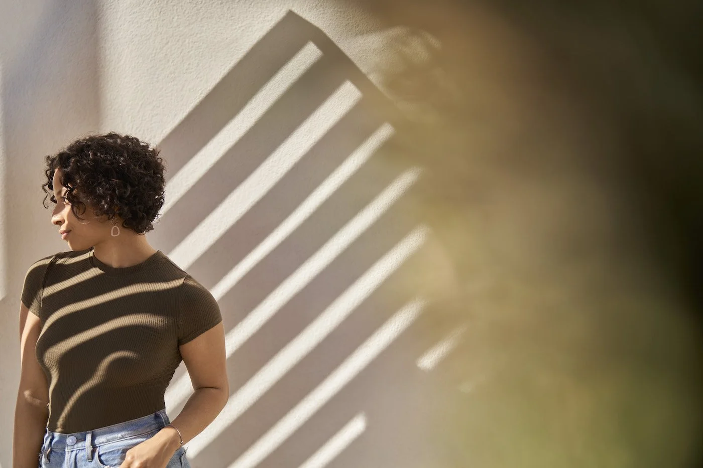 woman standing in front of a wall with diagonal shadows