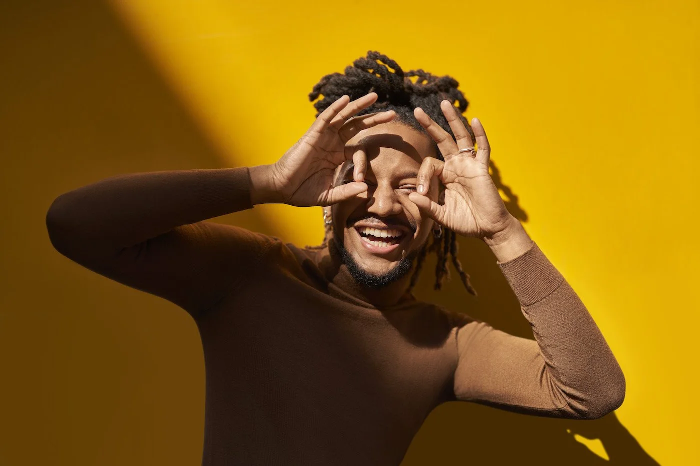 man standing in front of yellow wall