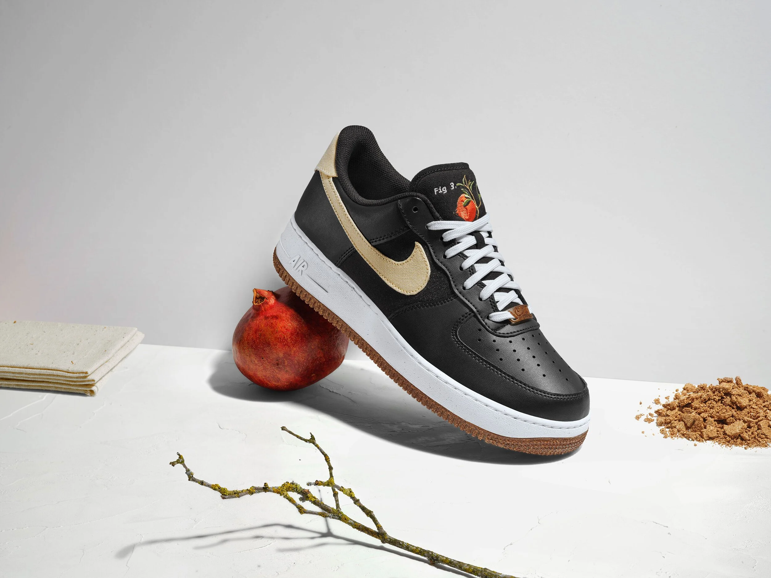 black nike sneaker on top of pomegranate