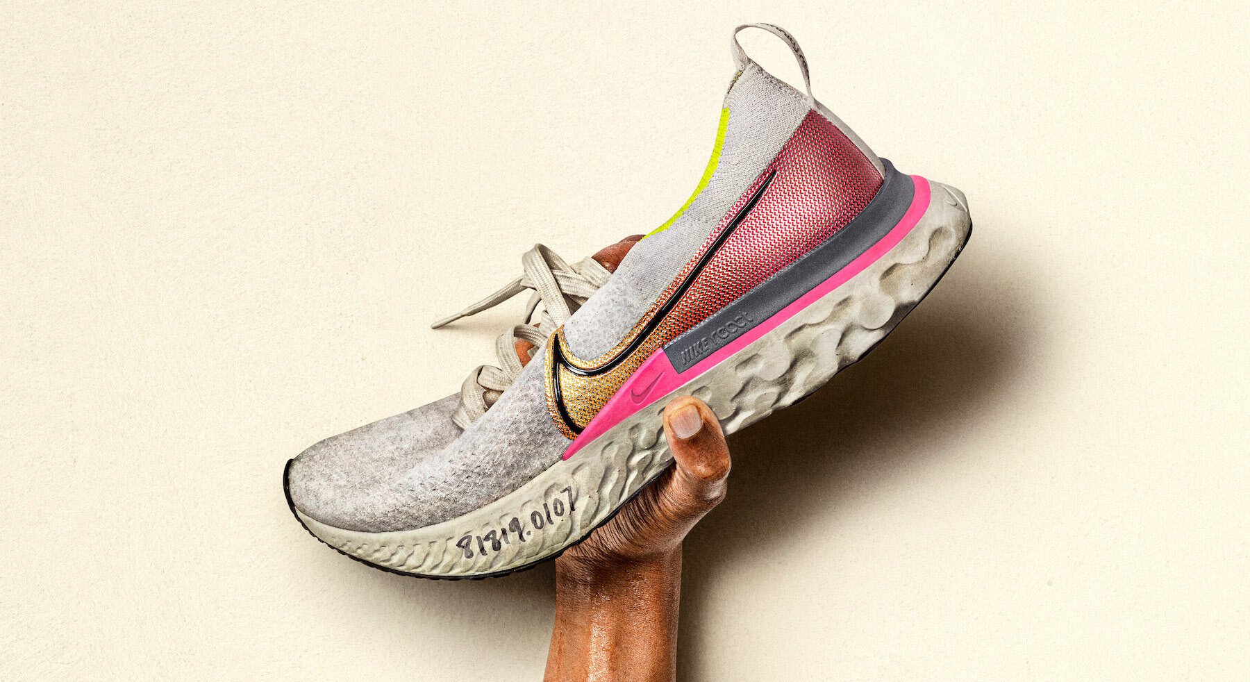 Hand holding Nike shoe up in air