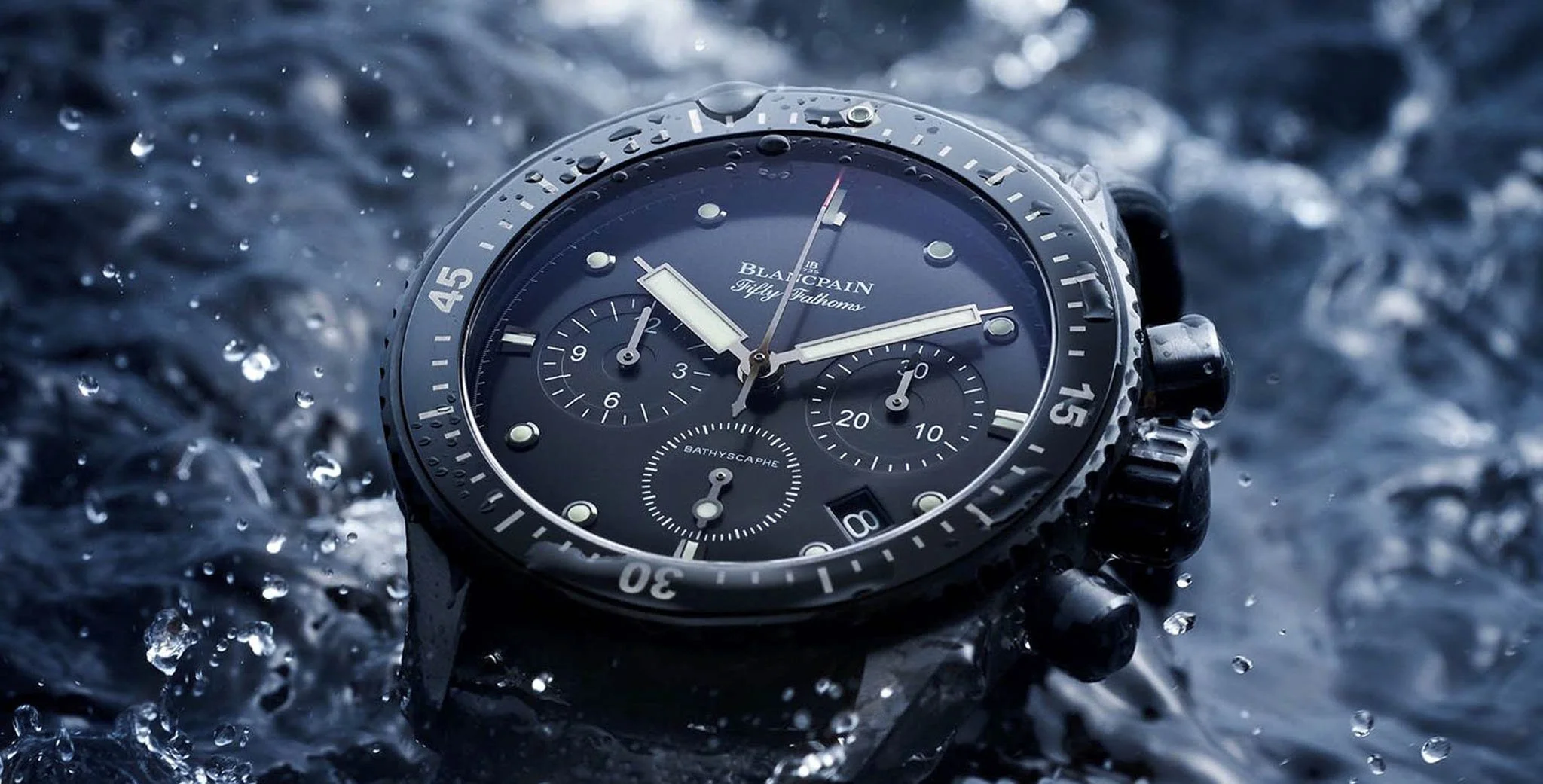 Nahaufnahme einer wasserdichten Blancpain Fifty Fathoms Bathyscaphe Taucheruhr mit schwarzem Zifferblatt und Chronographenfunktion im spritzenden Wasser
