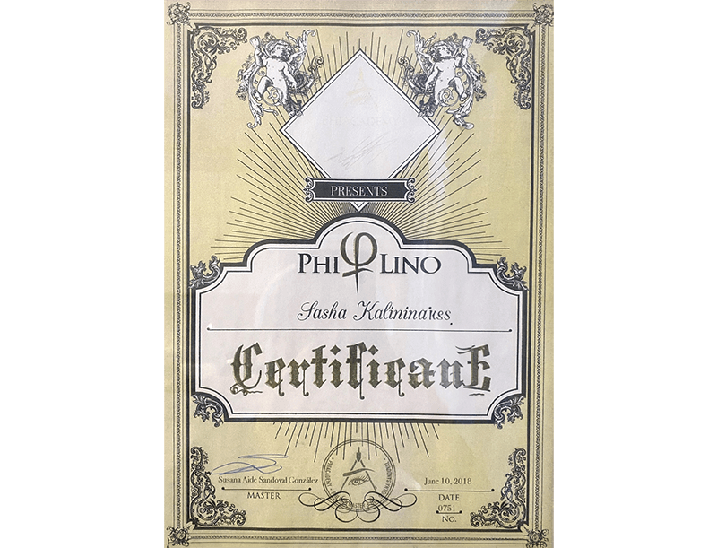 A vintage-style certificate with ornate borders, featuring a prominent omega symbol, rays of light, decorative corners, and a clock with an eye above it, awarded to Sasha Kalininakes on June 10, 2018.