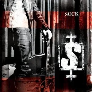 Partial view of a person with a suitcase standing in front of a graffitied wall with the word 'SUCK' and an underground symbol.