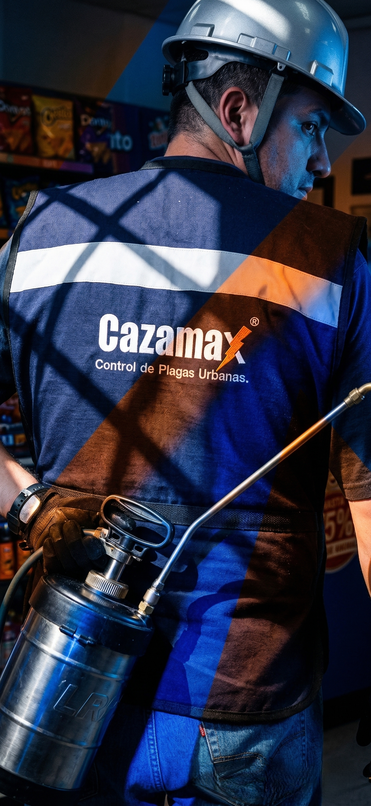 Persona con casco y chaleco con el logo de Cazamax, control de plagas urbanas, en un establecimiento.