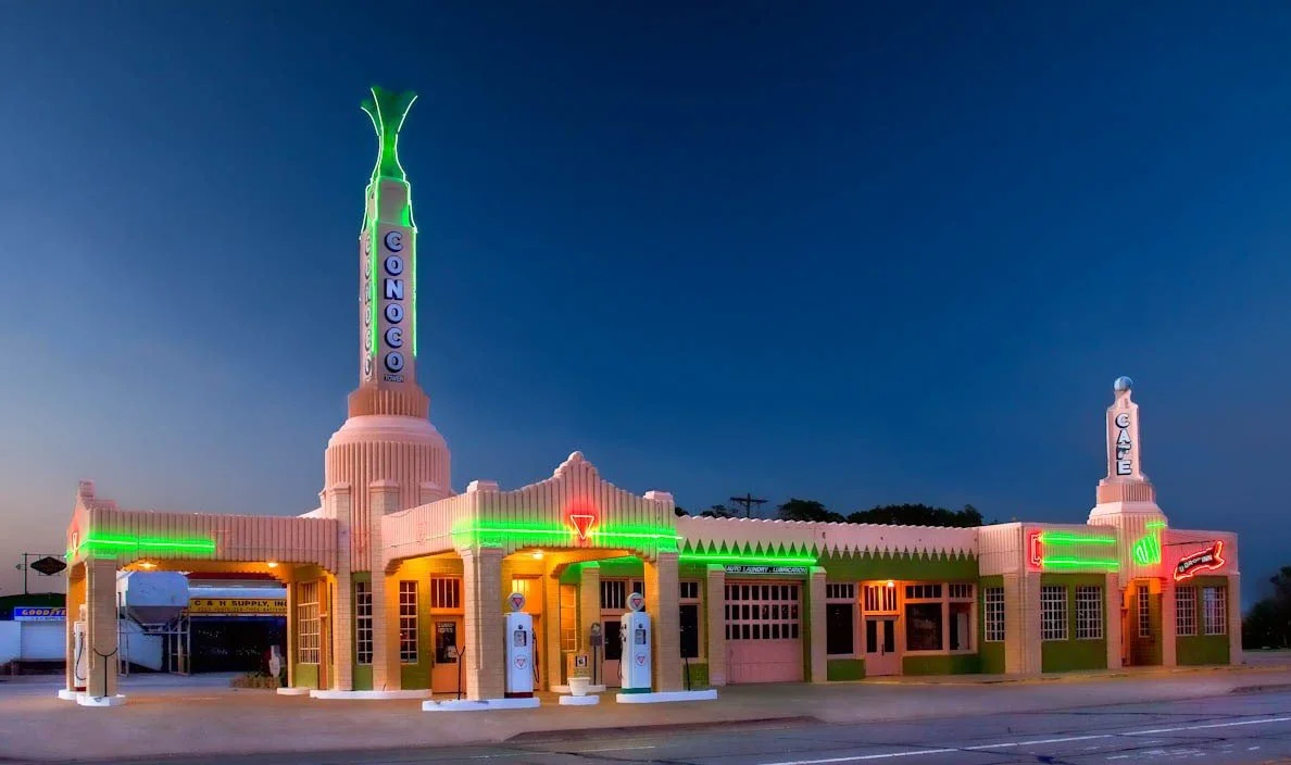 Vintage motel with neon signs and architecture resembling a 1950s roadhouse, during dusk or night.