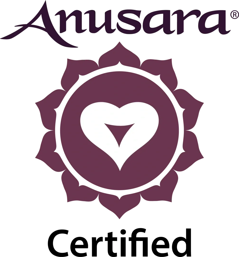 Logo for Anusara yoga with a purple lotus flower and a white heart-shaped symbol in the center.
