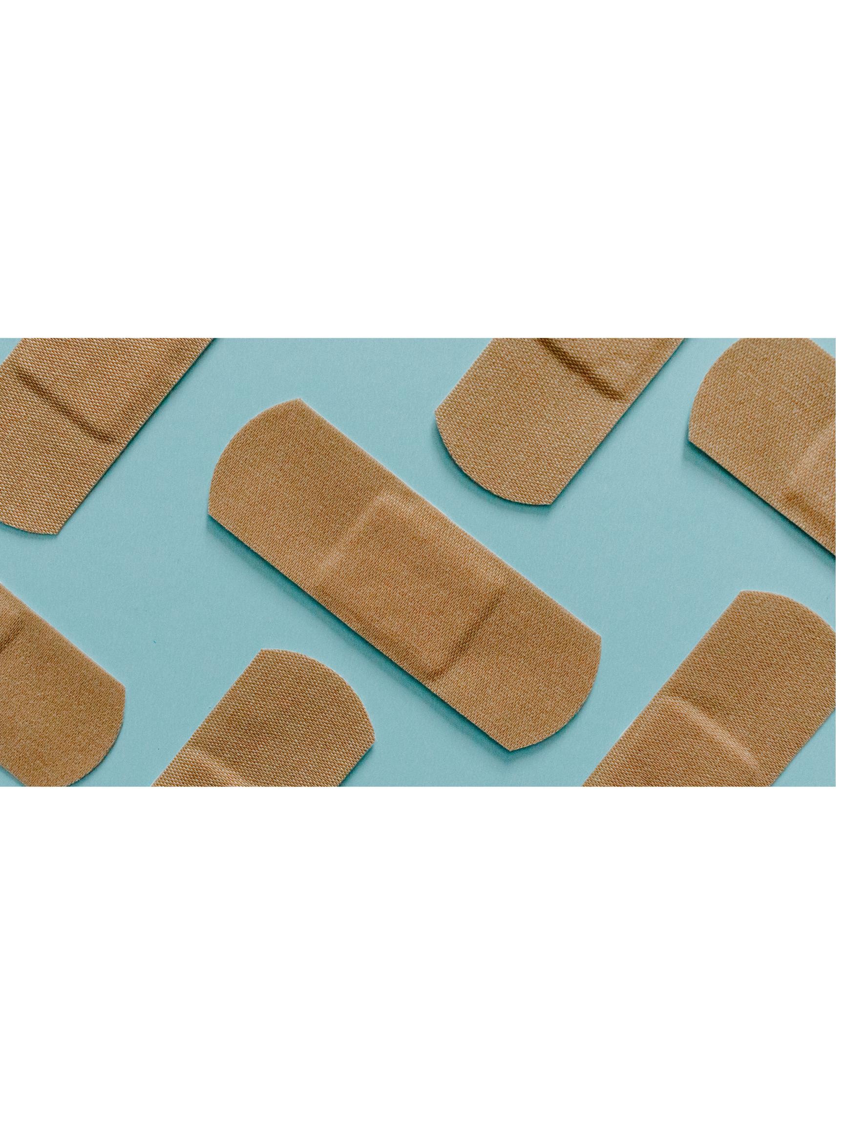 A collection of beige fabric bandages with rounded edges on a light blue surface.