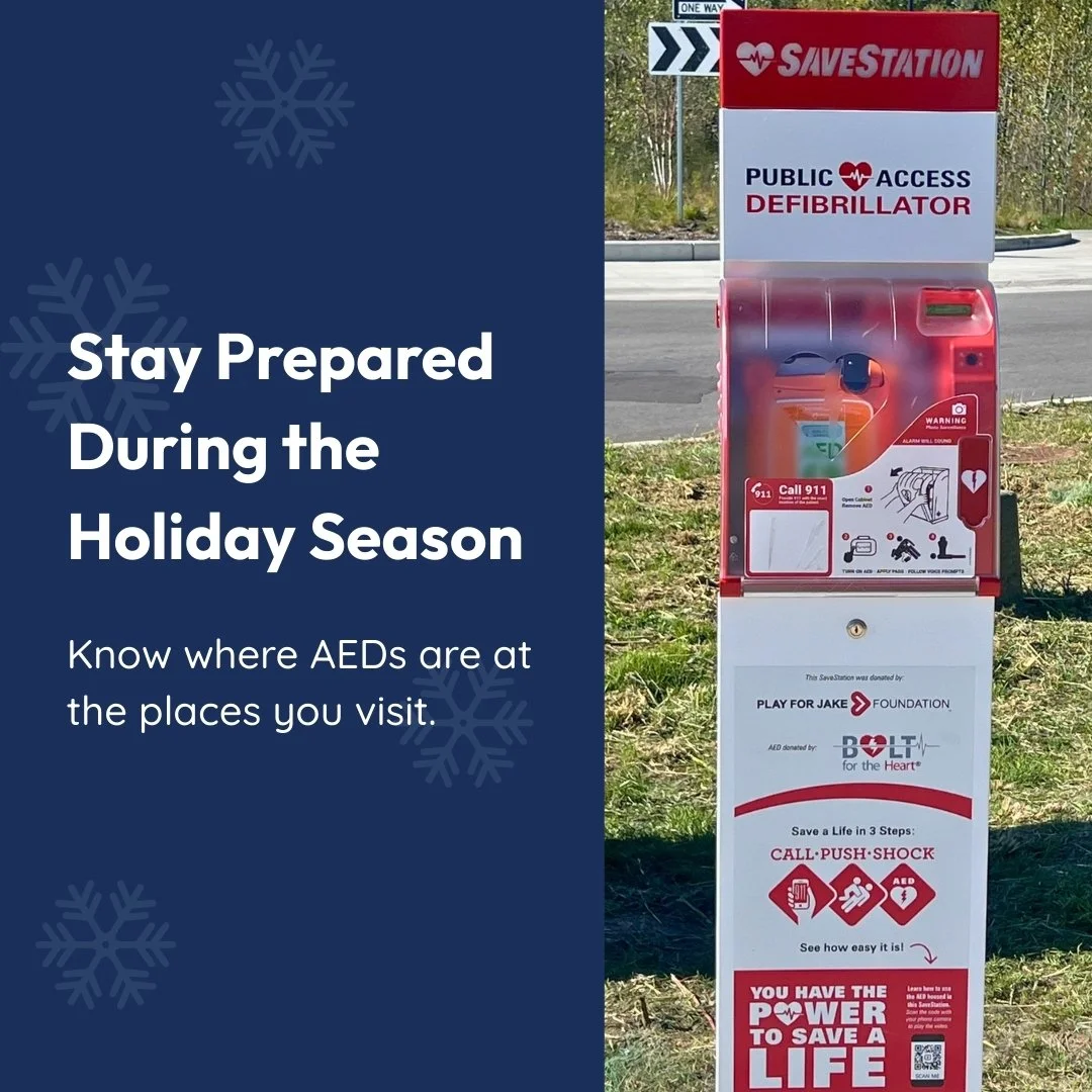 A public access defibrillator station outdoors with signage from Save Station, promoting awareness and preparedness for AED use during the holiday season.