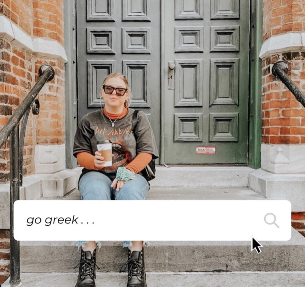 A young woman sitting on the stairs outside a brick building with a large green door, holding a coffee cup, wearing sunglasses, a graphic t-shirt, jeans, and combat boots.