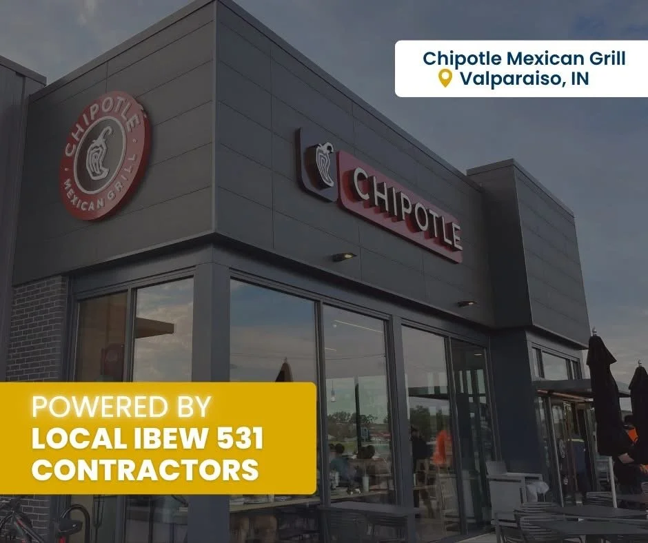 Exterior of a Chipotle Mexican Grill restaurant in Valparaiso, Indiana with signs and logos on the building, outdoor seating area, and a cloudy sky.