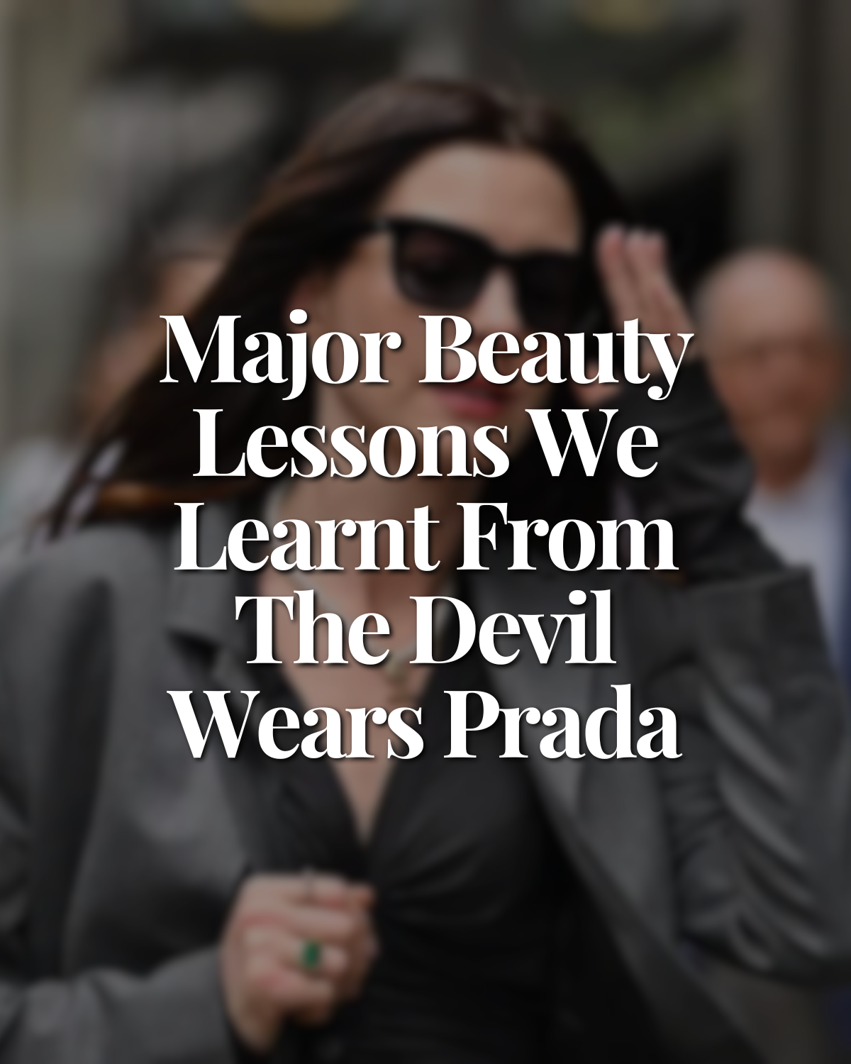 A woman wearing sunglasses and a black leather jacket, surrounded by people, holding her hand up to her forehead in a gesture of shading her eyes, with bold white text overlay that reads "Major Beauty Lessons We Learned From The Devil Wears Prada."