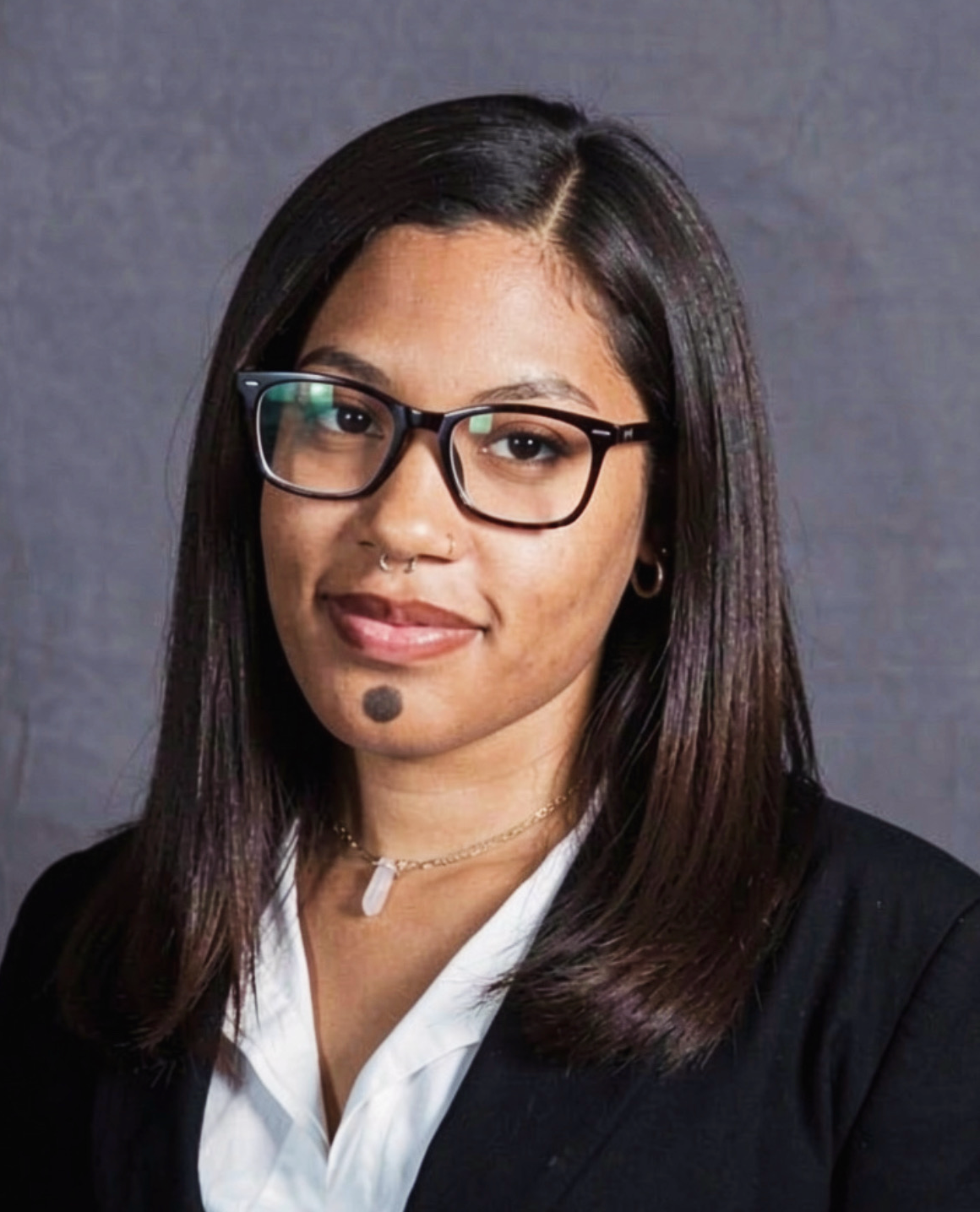 Headshot of smiling female tutor with long braids wearing a lanyard.