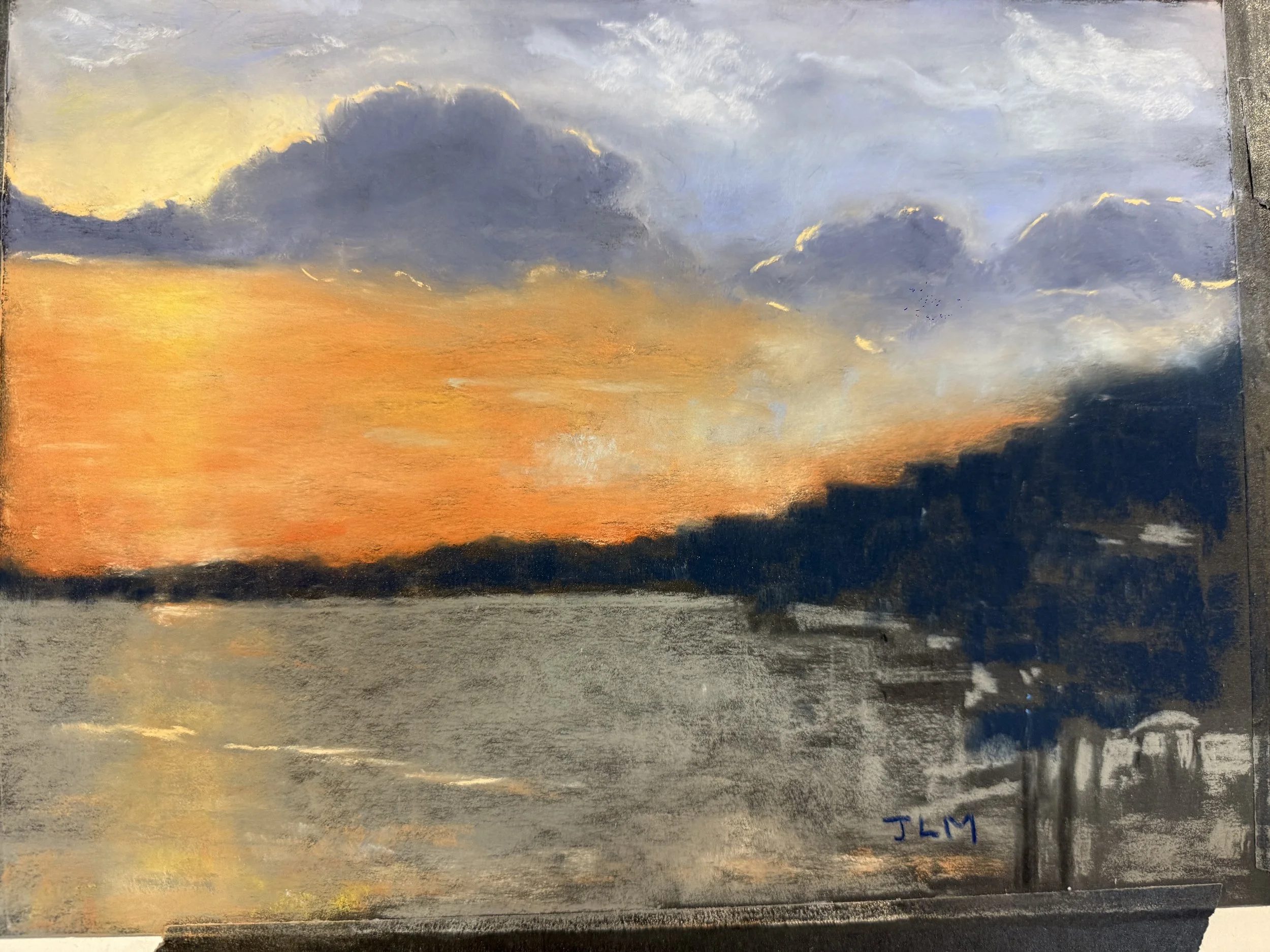 A painting of a sunset over a body of water with dark clouds in the sky, and silhouetted trees along the horizon. Signed with initials 'JLM' in the lower right corner.