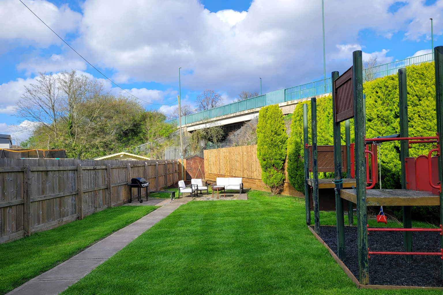 Lush backyard with play structure.png