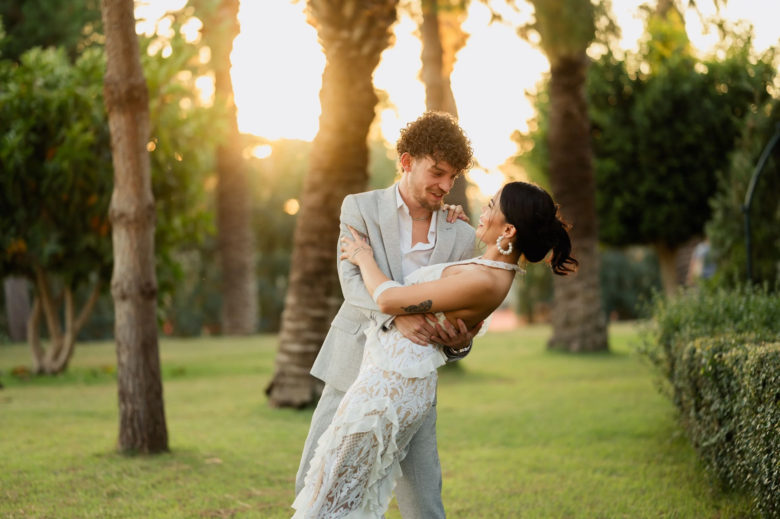 Couple dansant dans un jardin au coucher du soleil