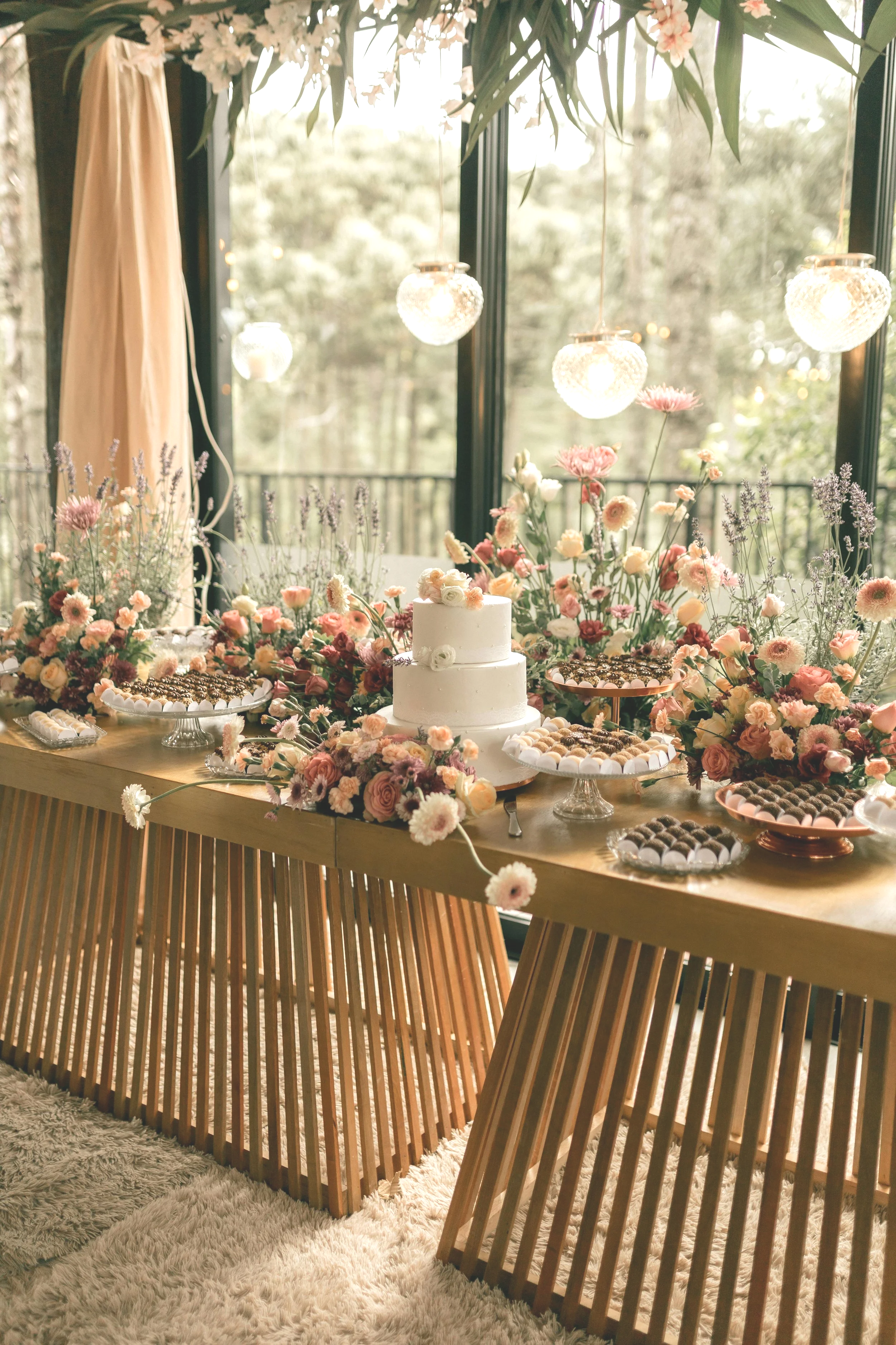 Table de desserts fleurie lors d'une réception de mariage