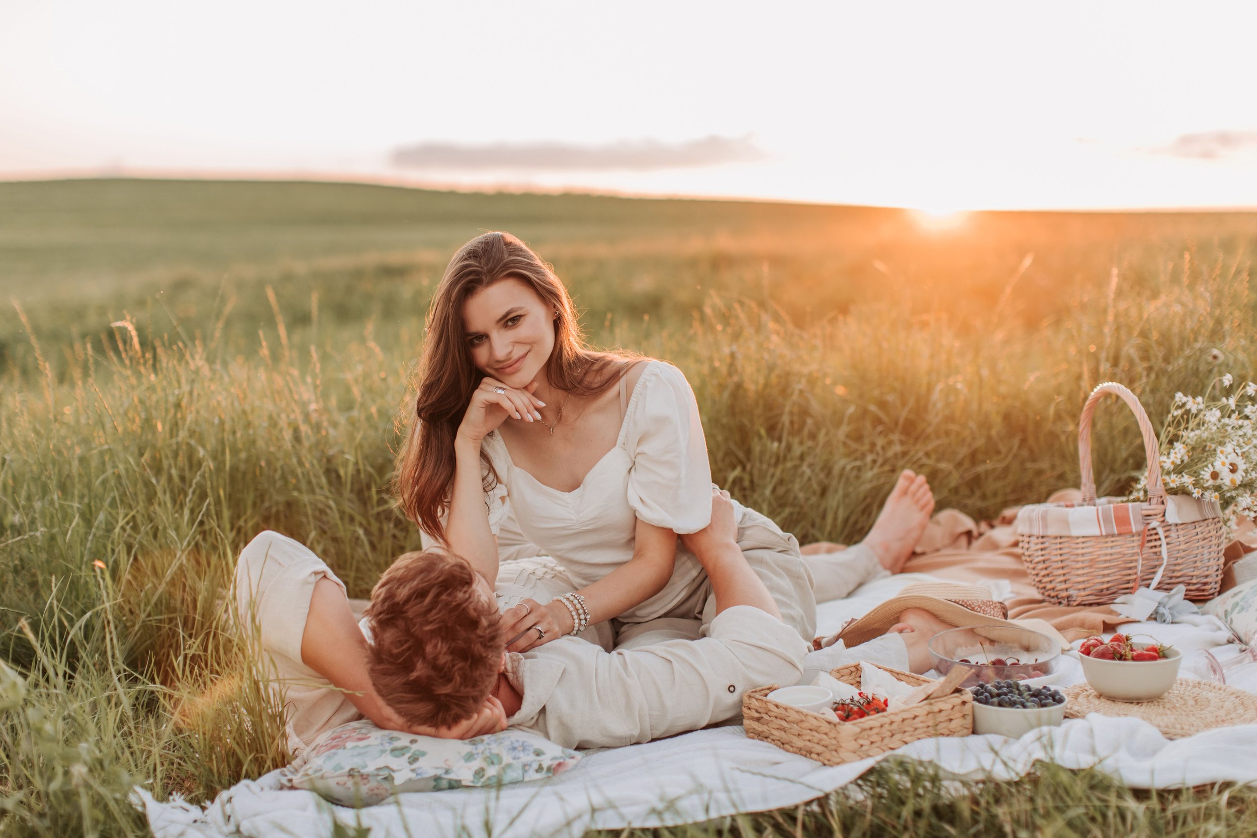Pique-nique en amoureux dans un champ au soleil couchant
