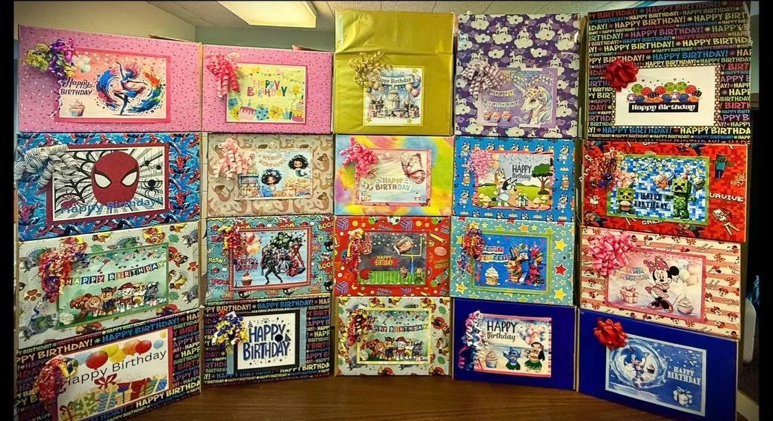 A variety of colorful birthday cards displayed on a table, with some cards decorated with ribbons and floral embellishments.