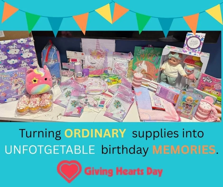 Display of colorful children's birthday supplies including decorations, toys, and gifts with a banner of multicolored flags and a message celebrating transforming ordinary things into unforgettable memories for Giving Hearts Day.
