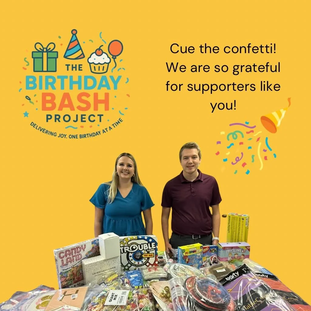 Two people standing behind a table filled with wrapped birthday gifts, with a yellow background and birthday-themed graphics, including a gift box, cupcake, balloons, party hat, and confetti.