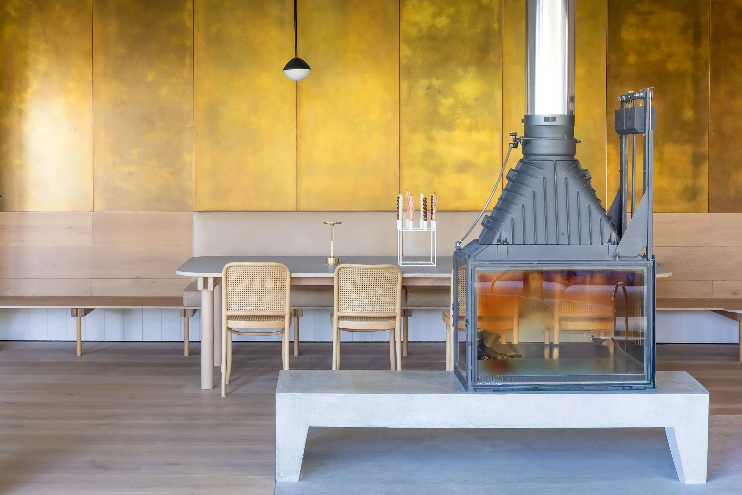 Modern interior photography with fireplace, timber seating and warm textured wall