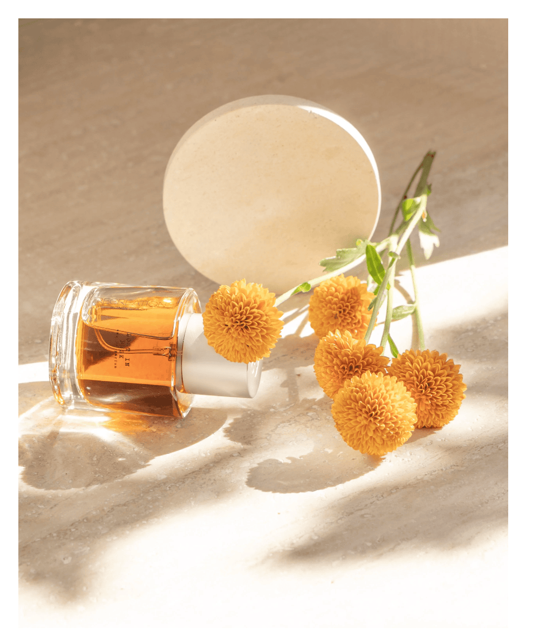 Styled product photography in Sydney featuring a perfume bottle and flowers captured in soft natural light with an editorial feel