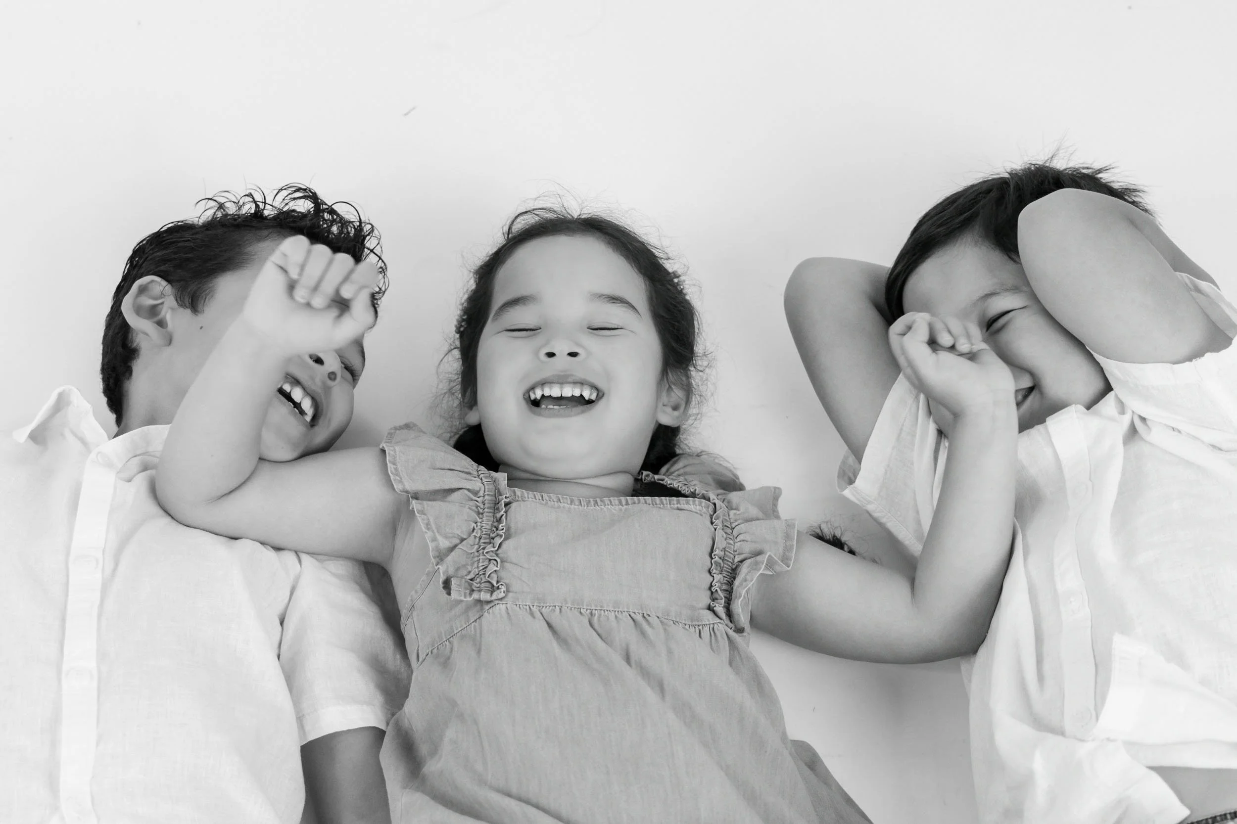 Black and white children laughing together in studio by Georgie Meadows Creative Sydney  