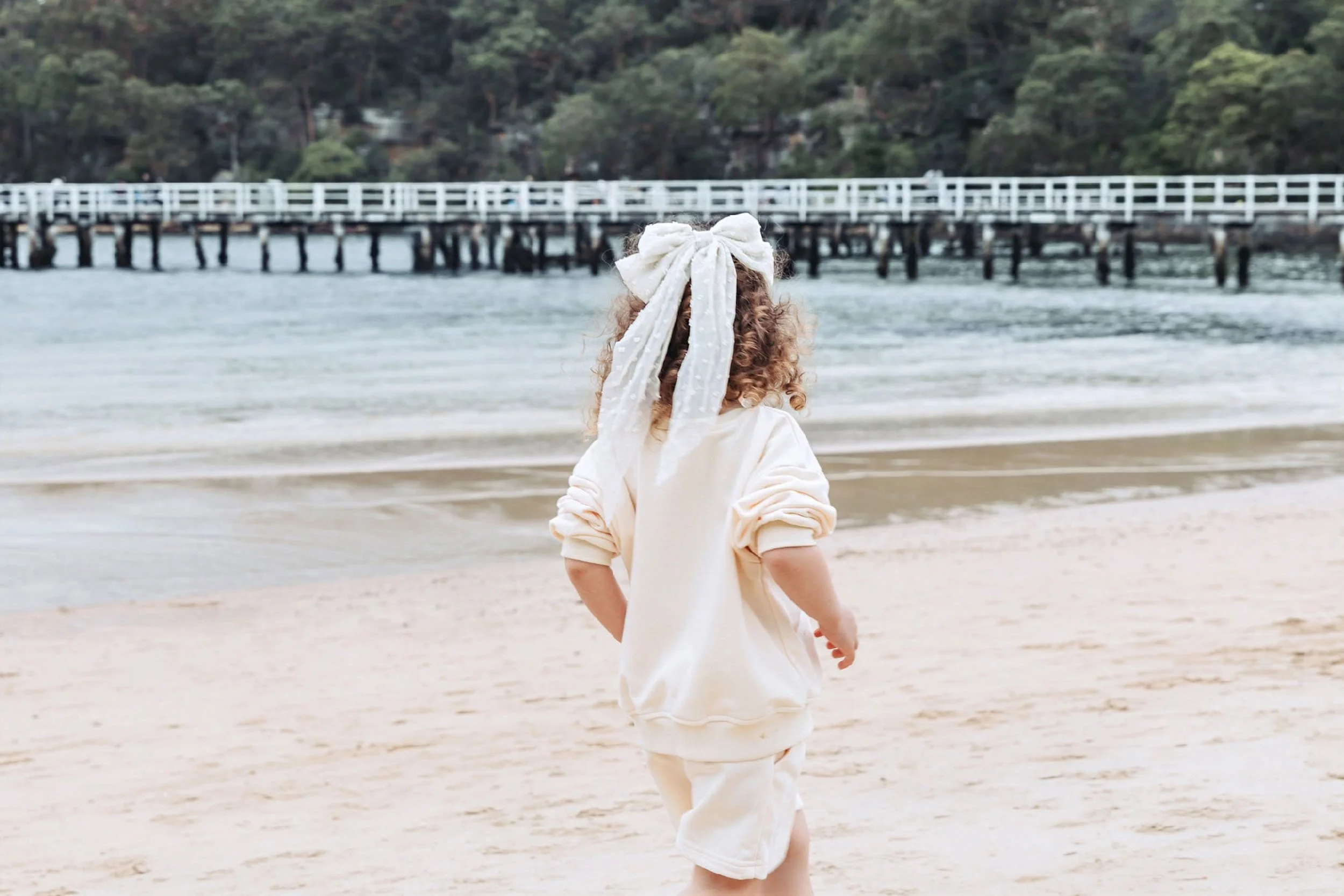 Child walking along the beach in soft natural light by Georgie Meadows Creative Sydney  