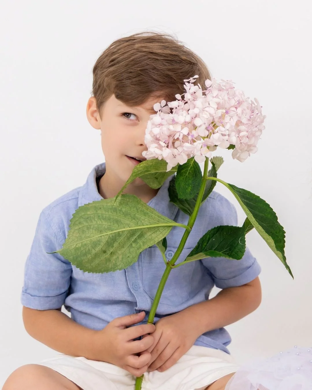 Sydney child portrait photographer capturing a relaxed natural light studio portrait with soft tones and flowers