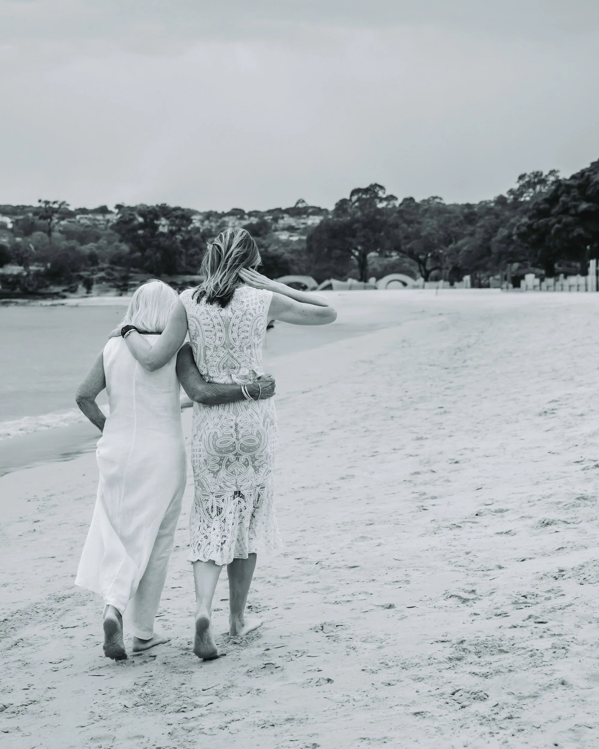 Black and white beach walk with mother and child by Sydney family photographer Georgie Meadows Creative