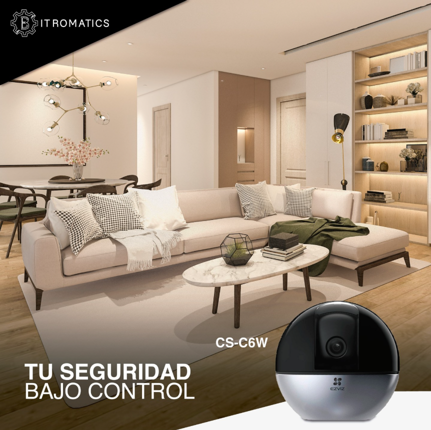 Imagen de una sala moderna y bien decorada con sofá gris, mesa de centro de mármol, estantería con libros y objetos decorativos, lámpara de pie, y una lámpara de techo con formas geométricas. En la esquina superior izquierda, el logo de IT ROMATICS. En la parte inferior derecha, una cámara de seguridad. Texto que dice: "Tu seguridad bajo control" y un código alfanumérico.