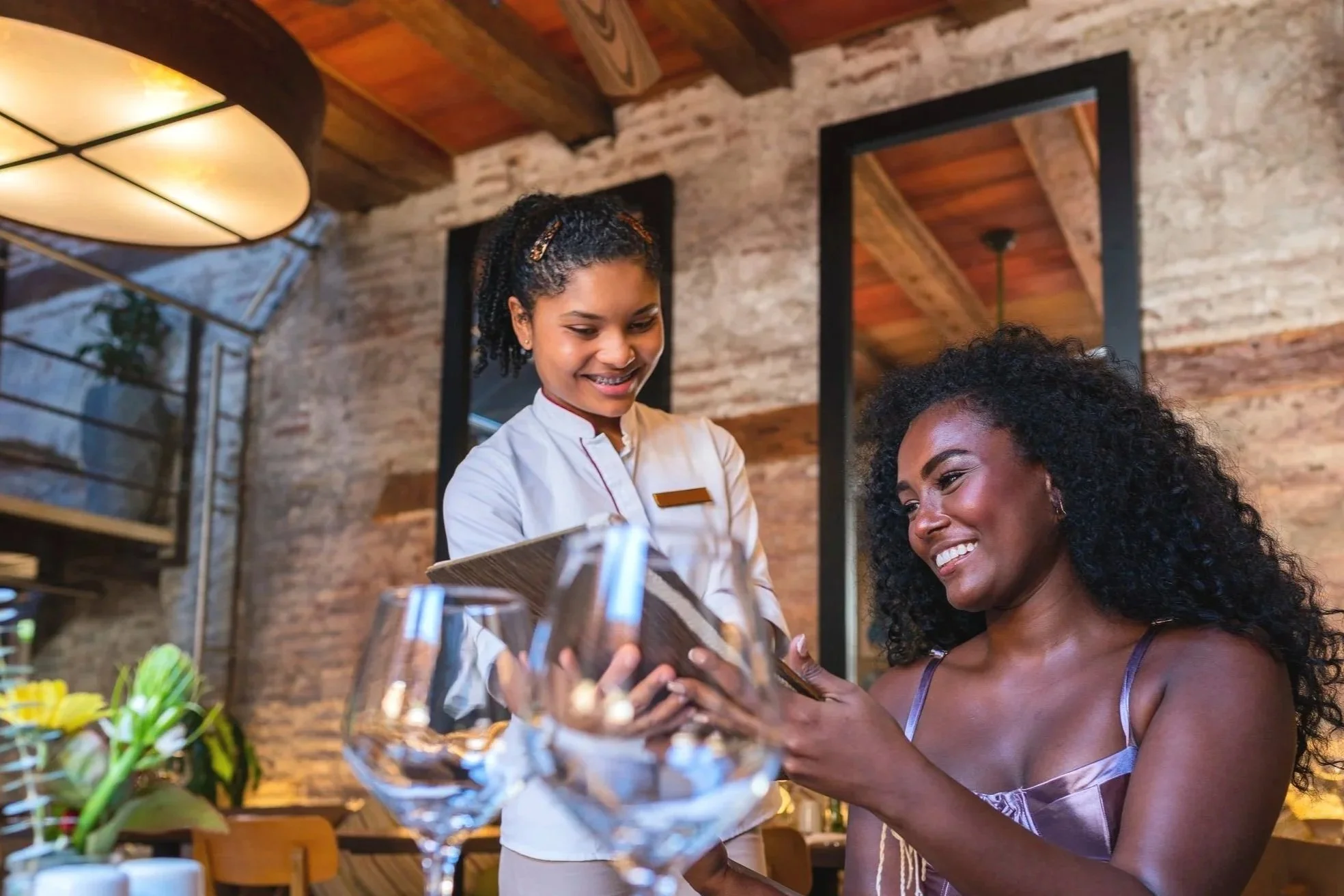 A waitress serving a woman at a restaurant table.