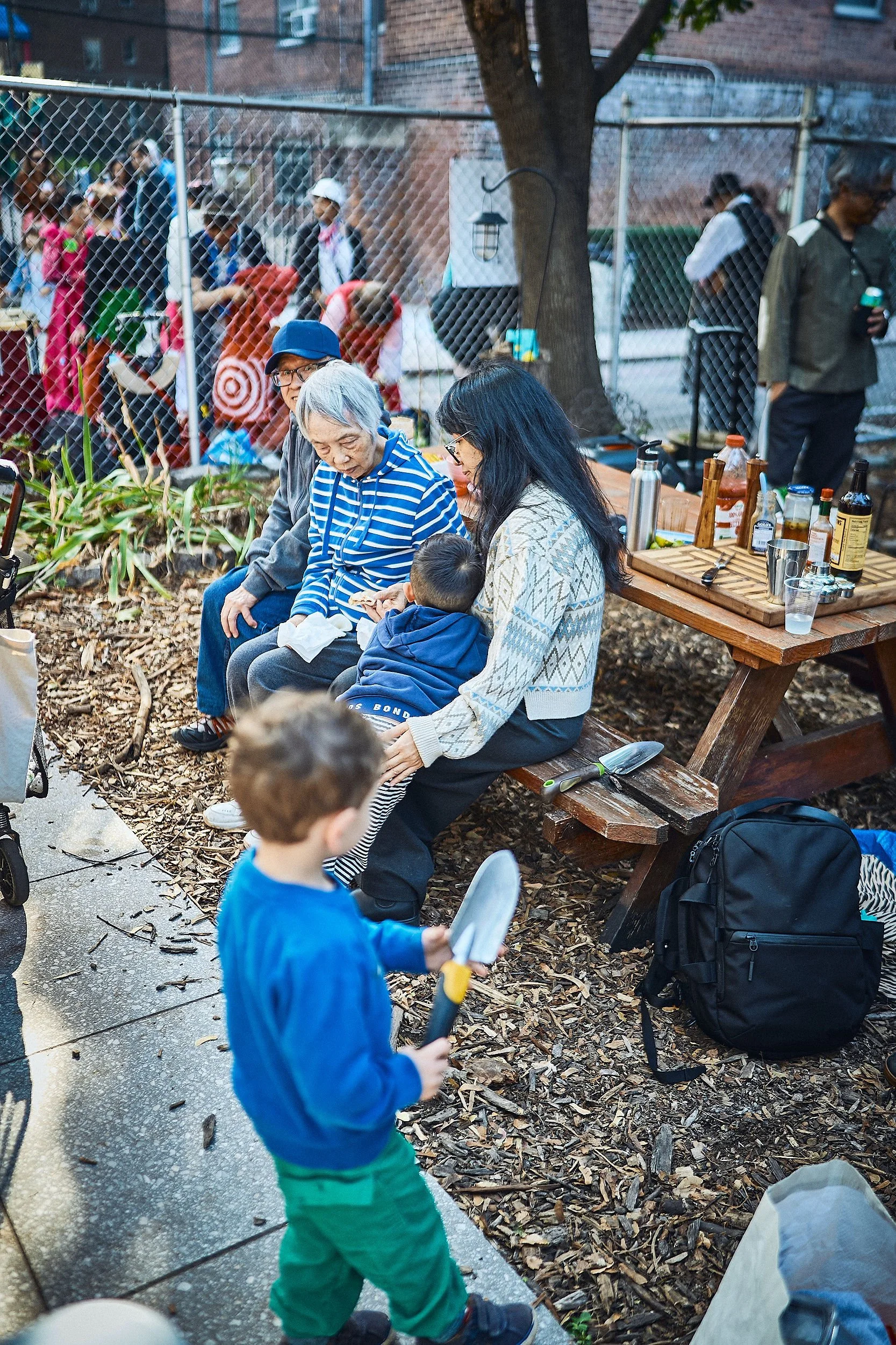 A family sitting at a picnic table at a community gathering