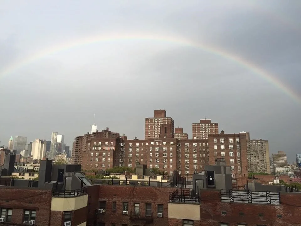 A rainbow arching over buildings.