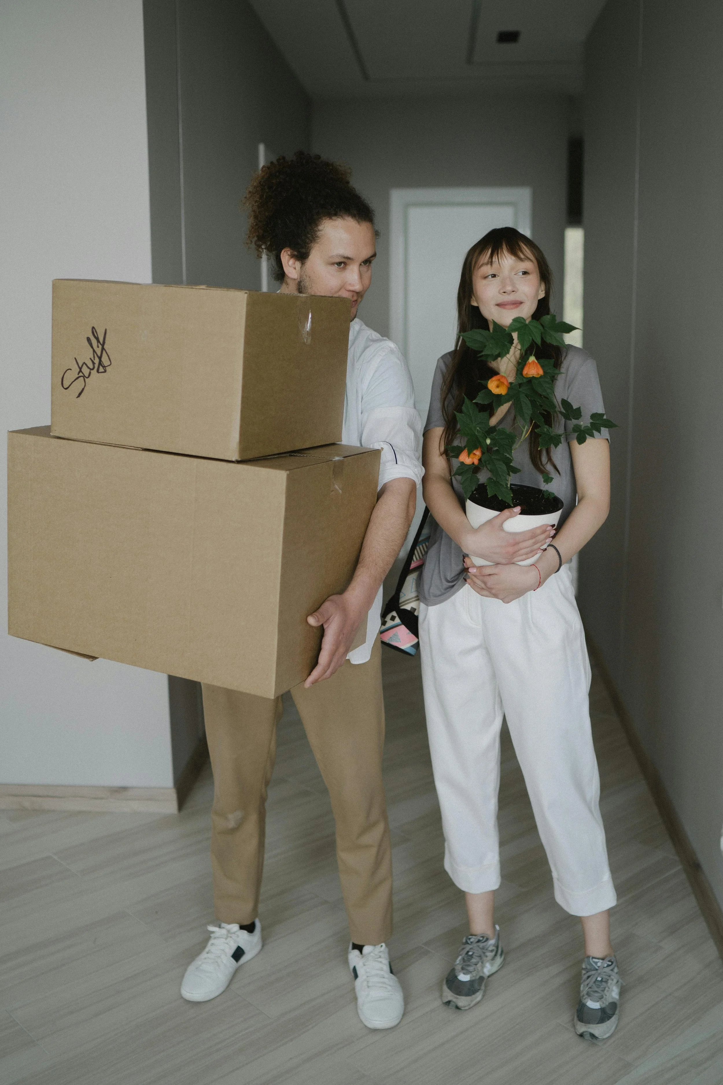 Two people cardboard boxes moving into their new home.