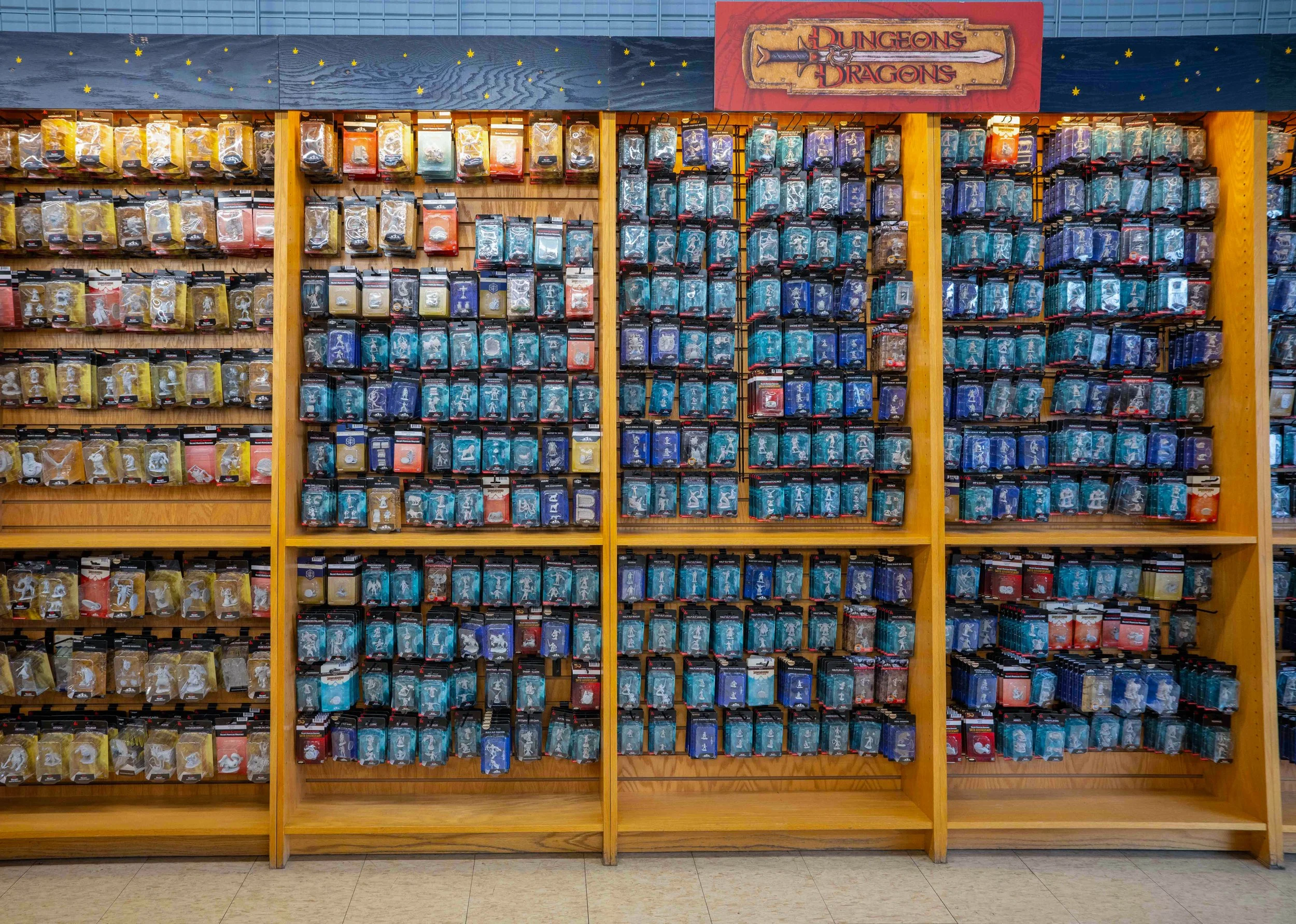 Shelves filled with Monster Hunter toy packs under a Dungeons & Dragons sign in a store.