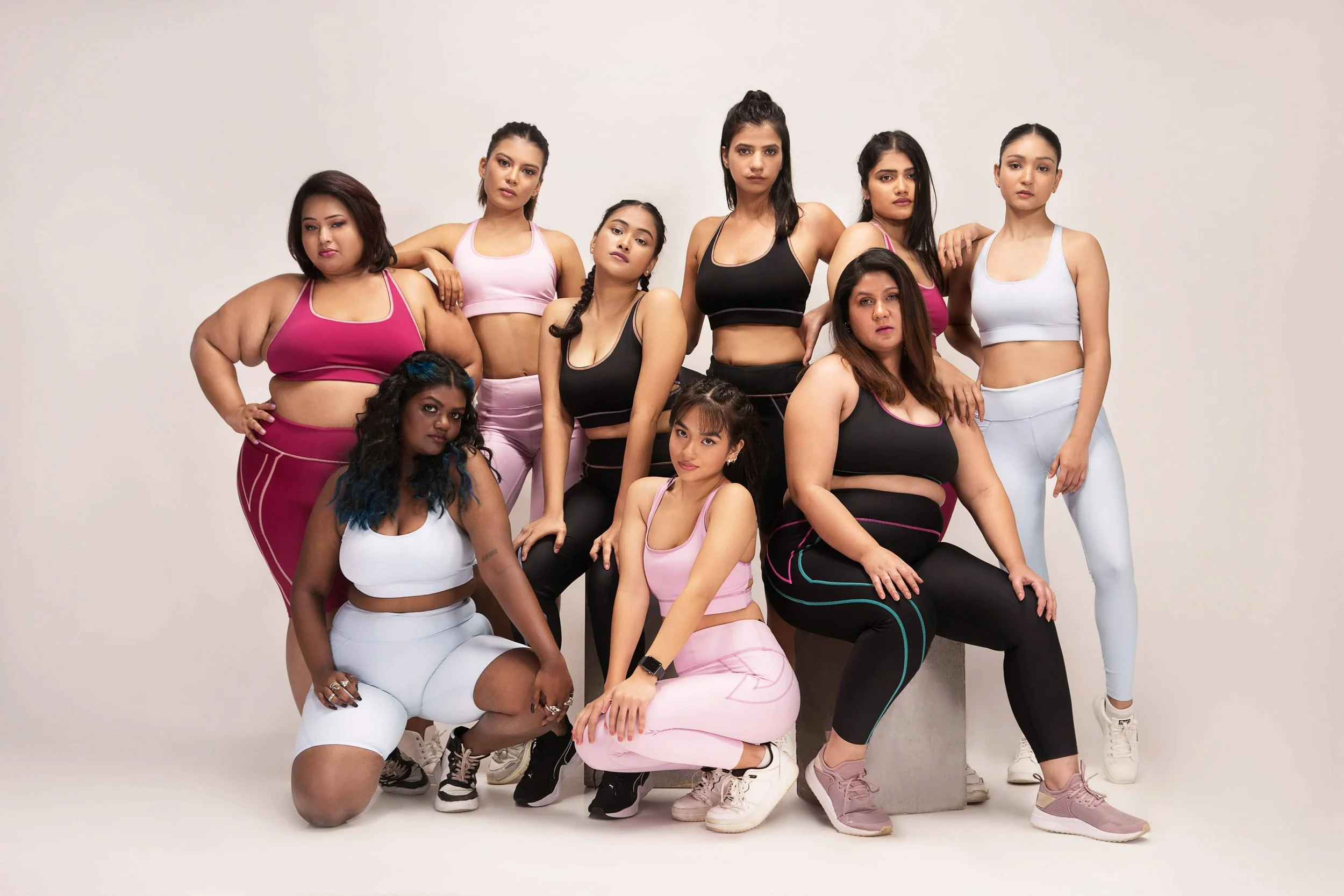 A group of diverse women, all wearing Pilates activewear sets.