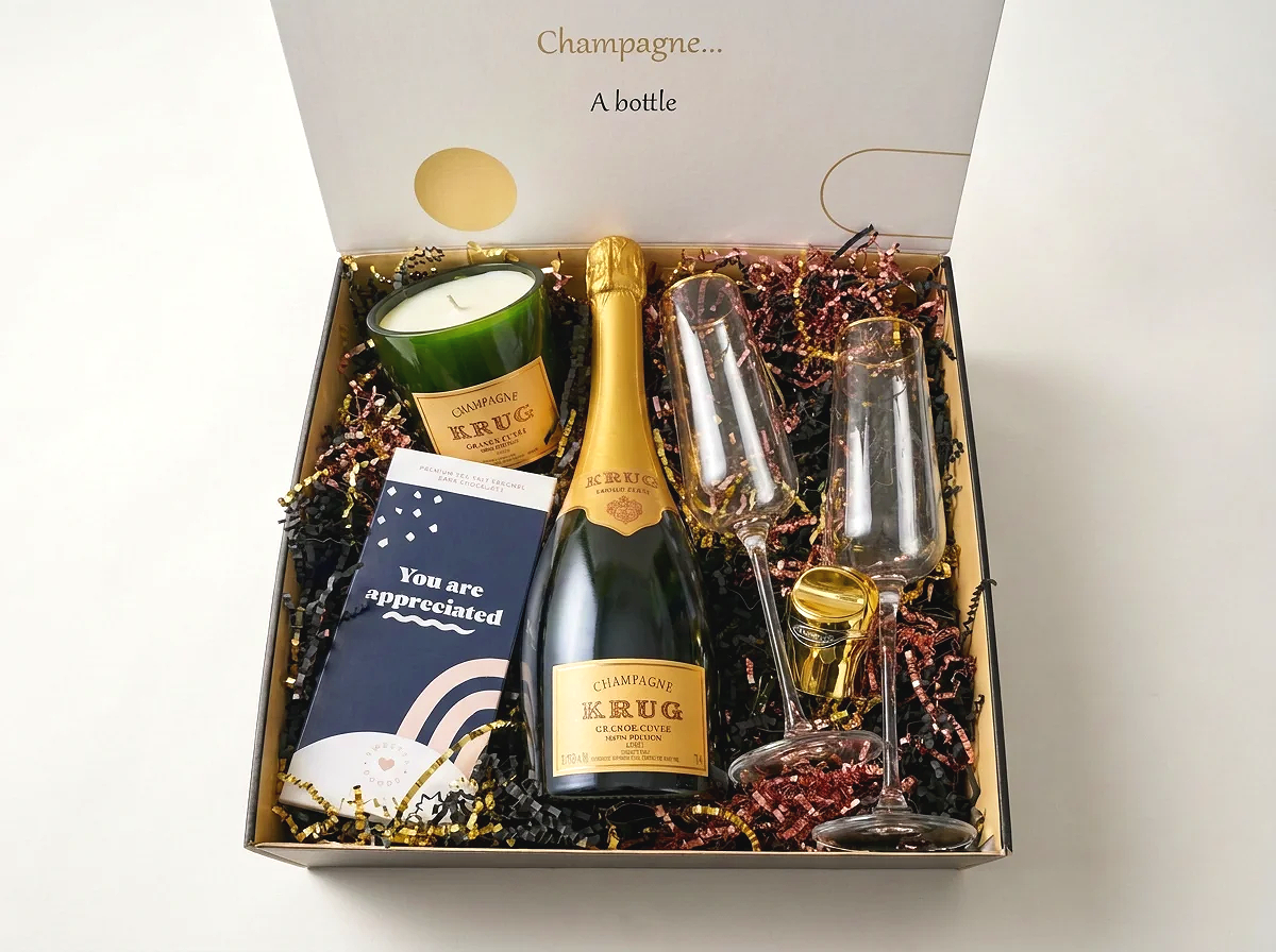 Champagne Krug gift box paired with candle and two gold rims flutes.png
