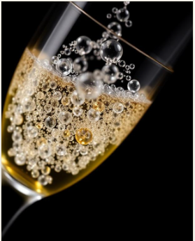 Close-up of a champagne flute filled with sparkling champagne and bubbles.