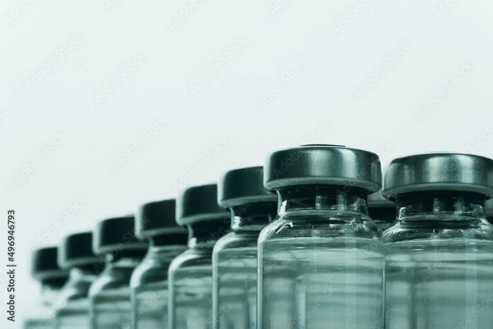 Row of glass medicine bottles with black caps