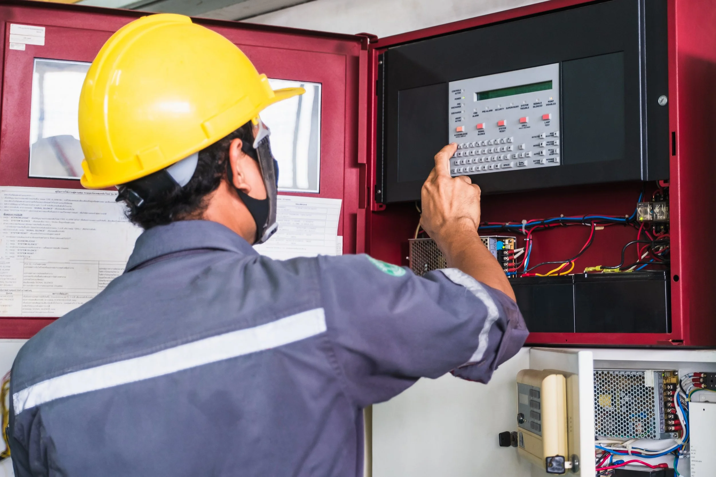 A technician working on emergency fire alarm repair services