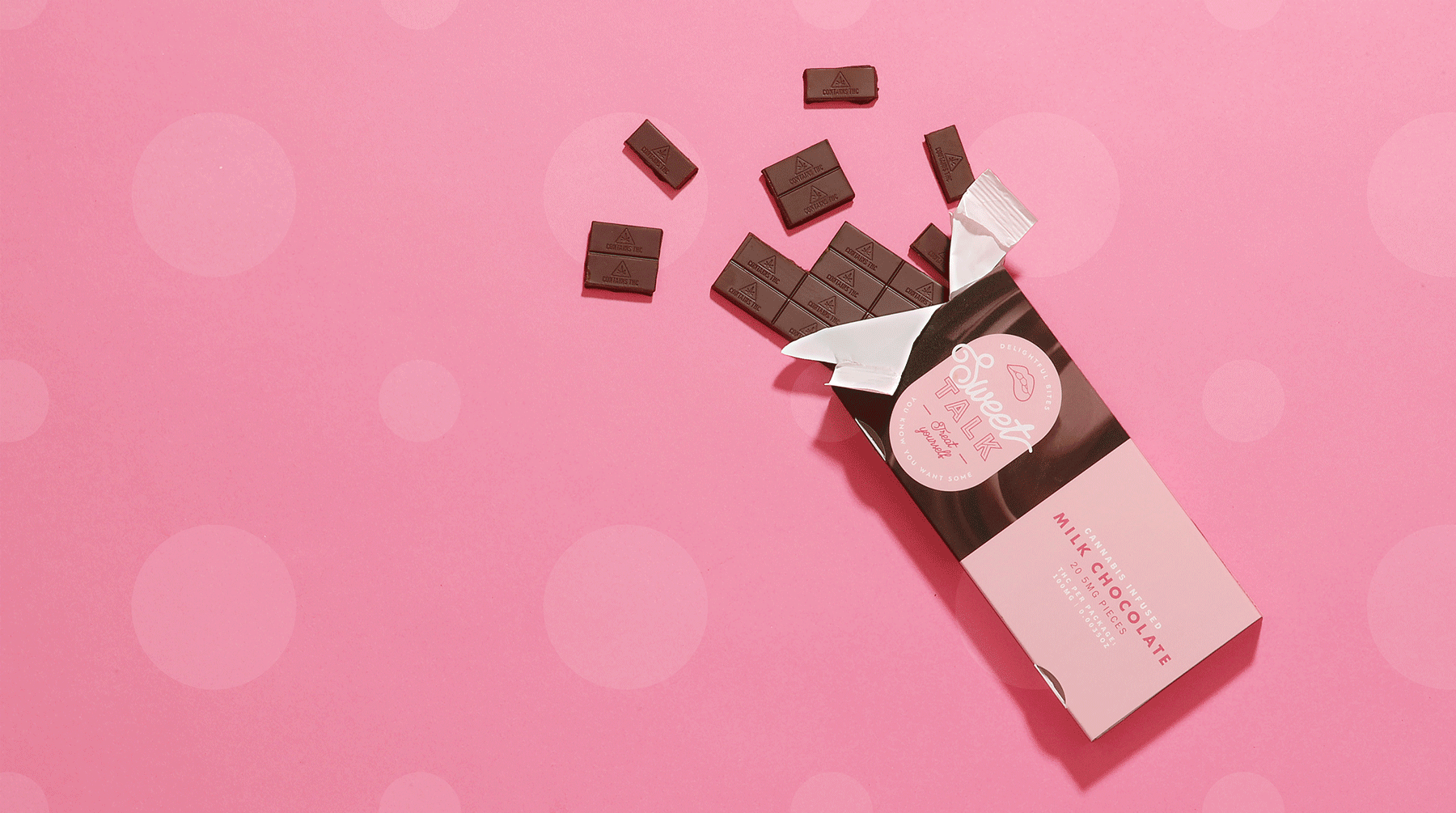 Pink box of Swaxot Talk milk chocolate with several chocolate pieces spilled out on a pink background.